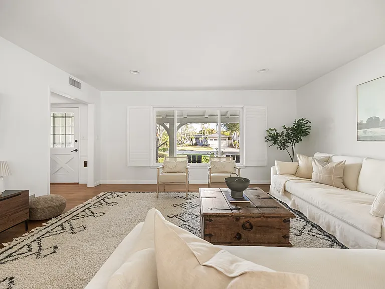Comfortable living room with generous seating and natural light that opens up to the dining area.