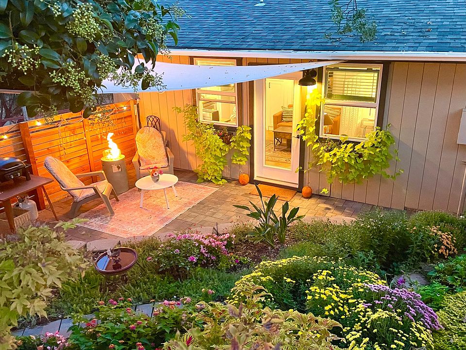 Patio at night with fire table. Perimeter of patio is strung with lights that are in a timer.