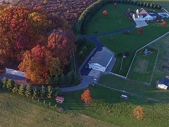 This view shows all three structures- The main house, the heated outbuilding with guest quarters and additional 5 bay metal gara