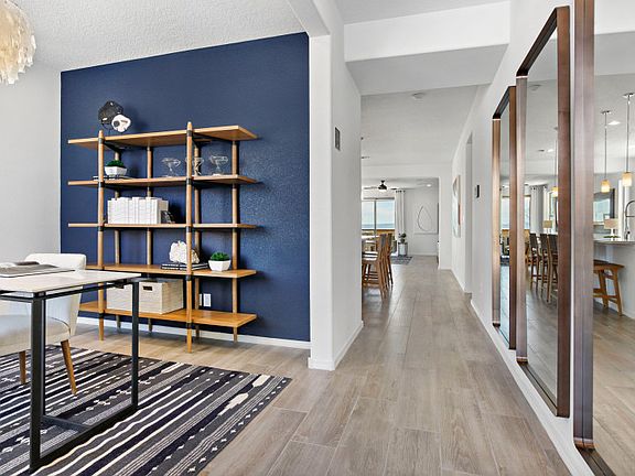 The foyer of the Hewitt featuring large accent mirrors and an opening to the spacious den.