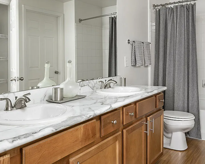 Apartment Bathroom with large soaking tub, Double Sink and hardwood flooring.