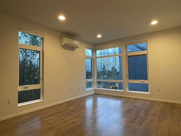 Living room with floor to ceiling windows and air conditioner