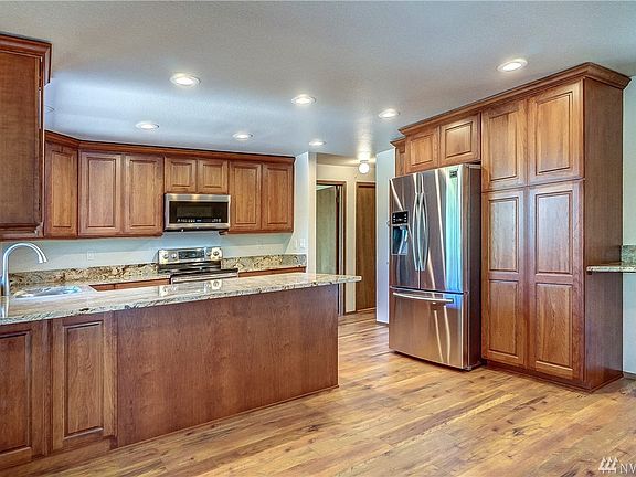 A well functioning kitchen with beautiful cabinetry and granite counter tops. 
