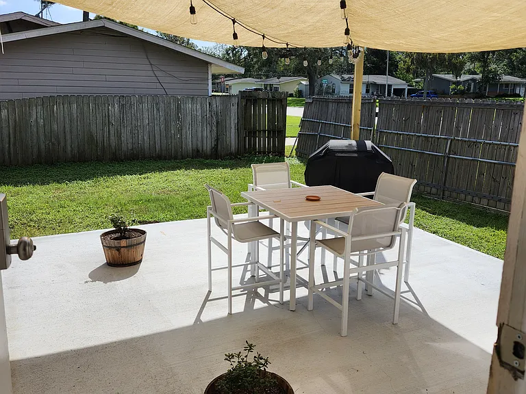 Patio with string lights, seating, table and propane grill