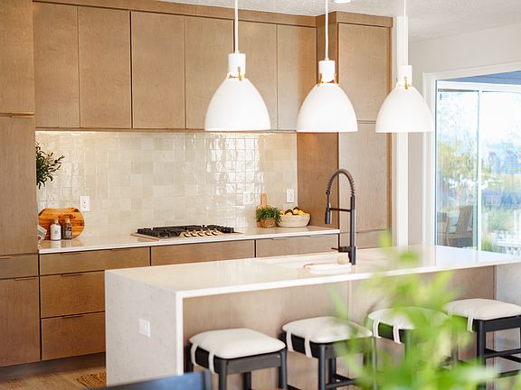 Modern kitchen from the Contempo Collection with light wood cabinets, white tile backsplash, and a c