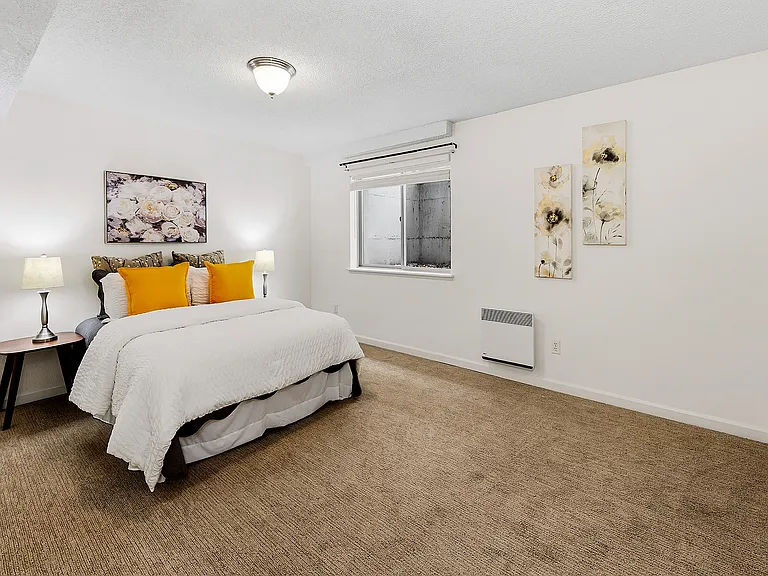 Large bedroom with new carpet and a wall of closet space.