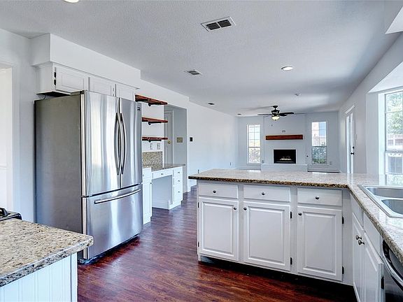 Kitchen boasts of granite counters & stainless appliances & open to family room...