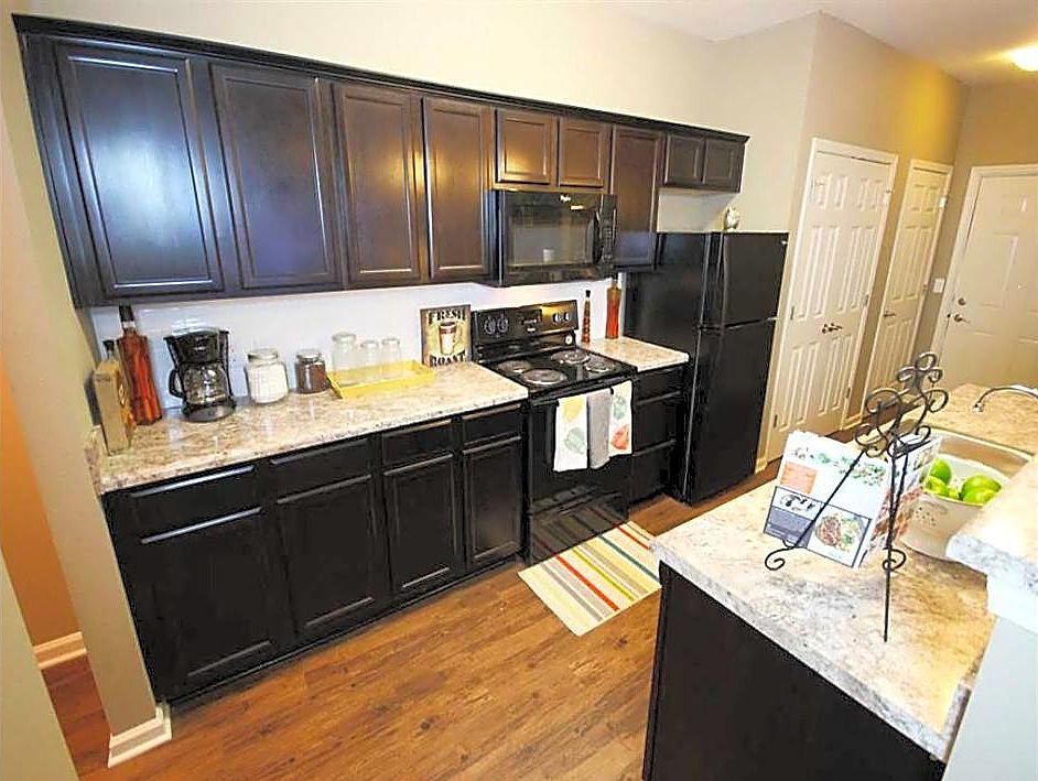 Fully equipped kitchen with beautiful cabinets and counter tops and matching energy efficient black appliances
