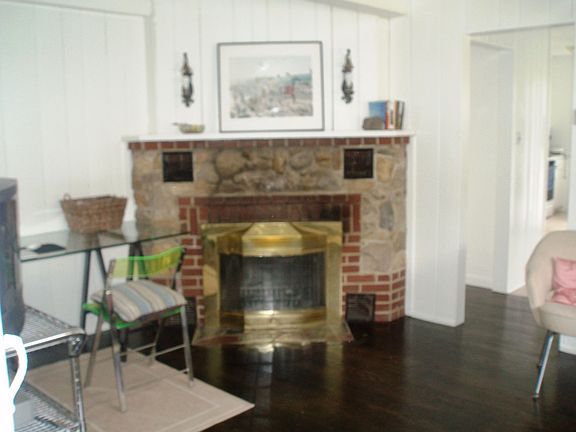 Living room with fireplace and wood floors throughout the house