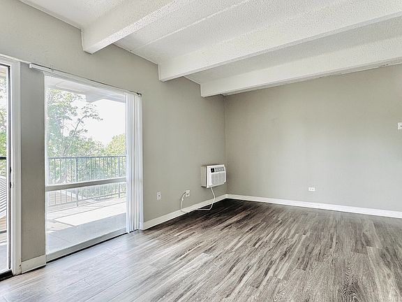 Bright and modern living room featuring stylish plank flooring, fresh two-tone paint, and an open-concept layout_perfect for relaxing or entertaining.