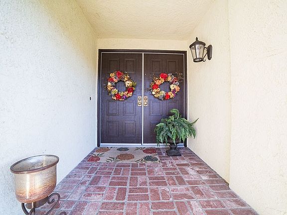 Brick floored, covered front porch leads to solid