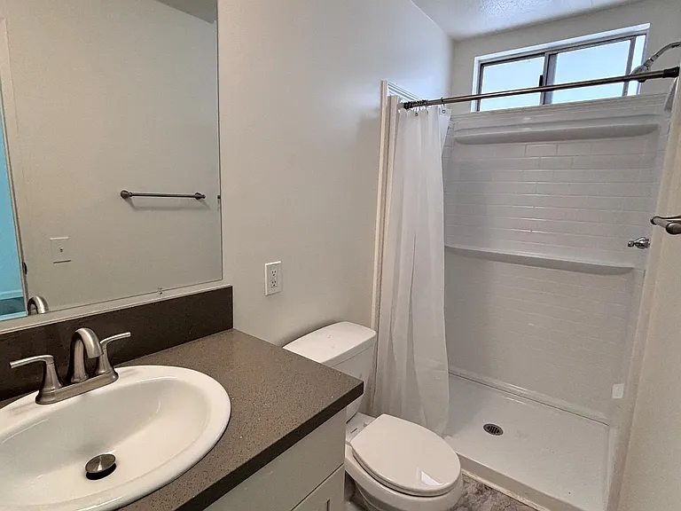The primary bathroom offers a private, well-appointed space designed for both comfort and convenience. Featuring a functional layout with ample counter space and storage, it provides everything needed for a smooth daily routine.