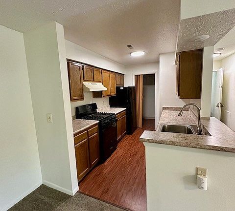 View of the galley style kitchen- laundry is the far opening at the end of the kitchen