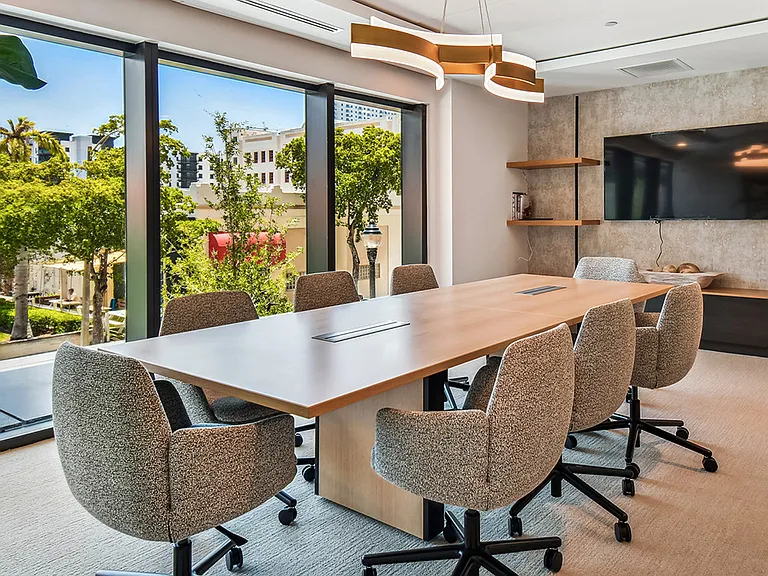 Griffis West Palm apartments coworking lounge conference room with large conference table.