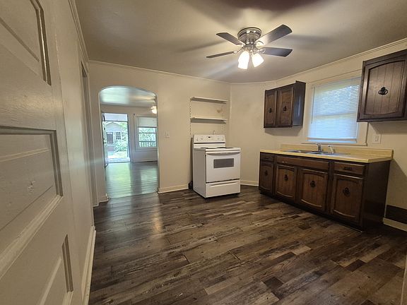 Kitchen with electric stove, double sink and cabinets. from pantry.
