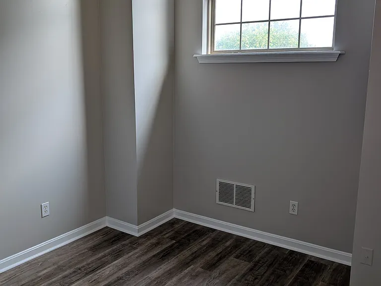 Versatile upper-level flex space/loft featuring an arched window and new luxury vinyl plank flooring