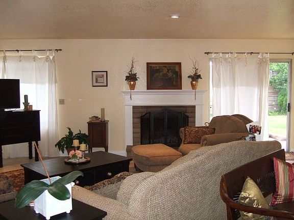 Living room with brick fireplace and tile floors