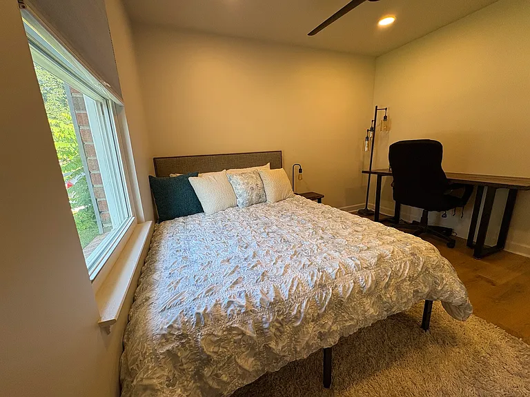 Guest bedroom with a desk and closet.