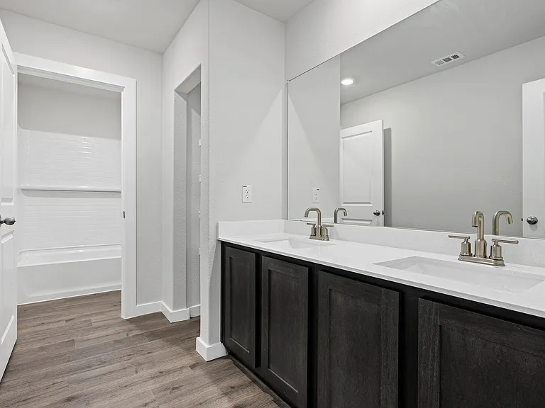 The secondary bathroom has a vanity space and a shower-tub combo.
