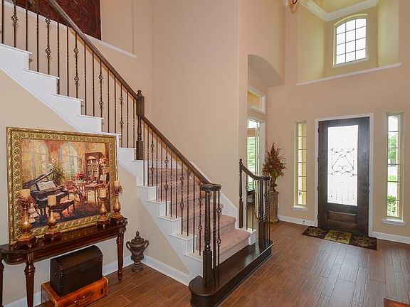 Warm entry. Elegant wrought iron spindles on staircase.