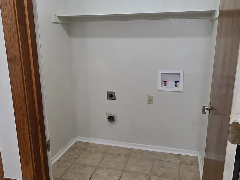 laundry room off breakfast leading to garage for a full size washer and dryer with double shelf