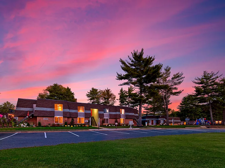 Haynes Run Apartments at sunset, featuring warm lighting, lush grounds, and peaceful surroundings in Medford, NJ.
