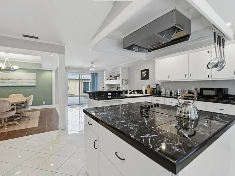 Spacious kitchen with large island, ample cabinetry, and sightlines to the dining area and patio doors.