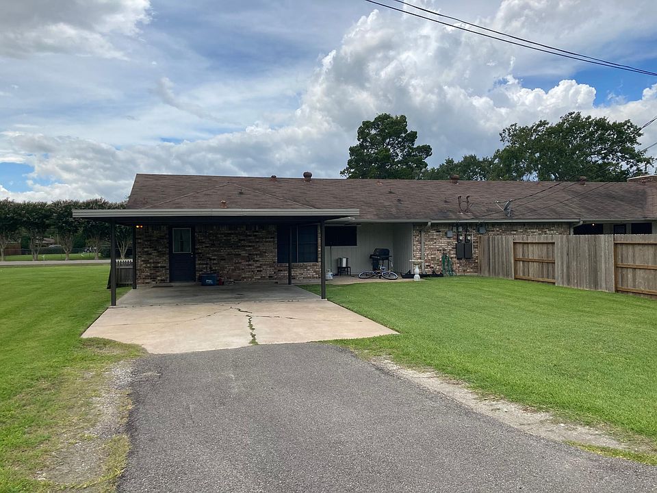 Drive leading to covered parking and private covered patio and back yard.