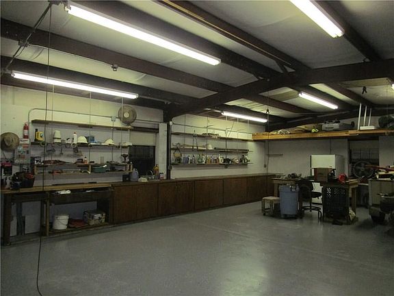 Workshop with sink, built in cabinets, and shelving.
