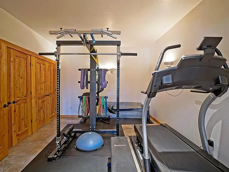 Large bedroom closets and home gym with treadmill, bike, rowing machine and weight machine
