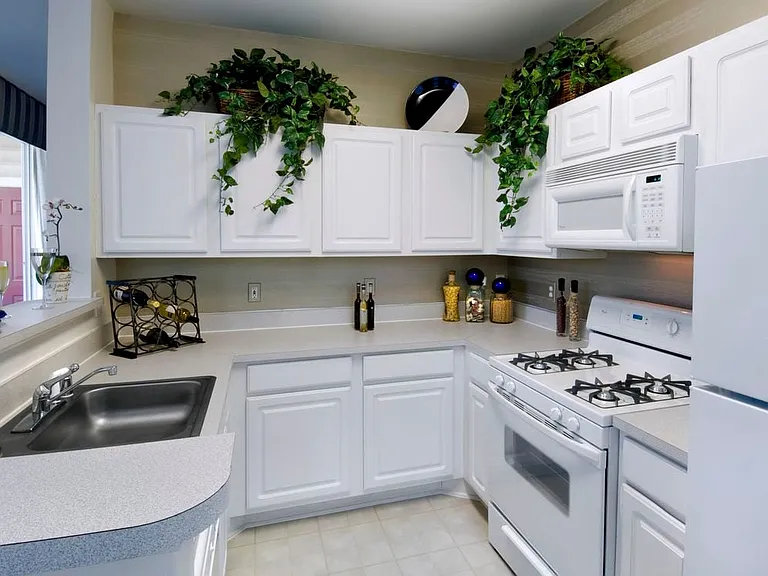 Classic Package kitchen with white cabinetry, light grey laminate countertops, white appliances and tile flooring