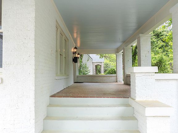 Spacious tiled front porch from drive through carport