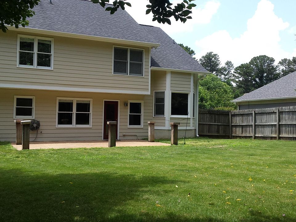 large flat fenced yard with large brick patio  