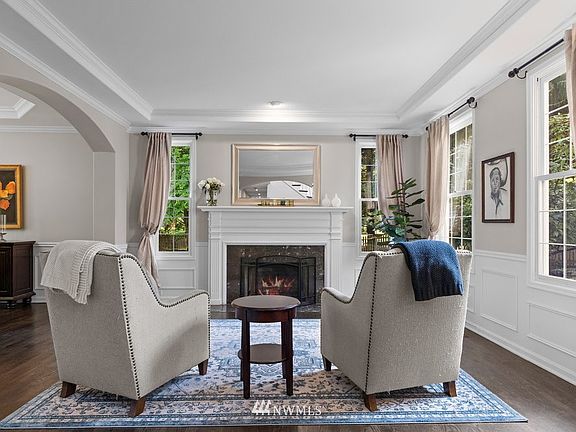 The formal living room and dining flow together and both feature crown molding and wainscoting.>