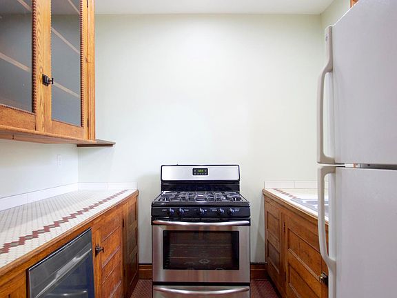 Galley kitchen with stove, fridge and dishwasher