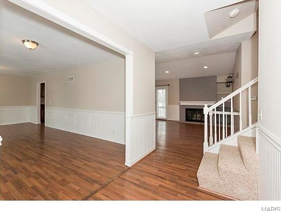 View from the entry. Living room to left with laminate flooring that flows into hearth room and brea