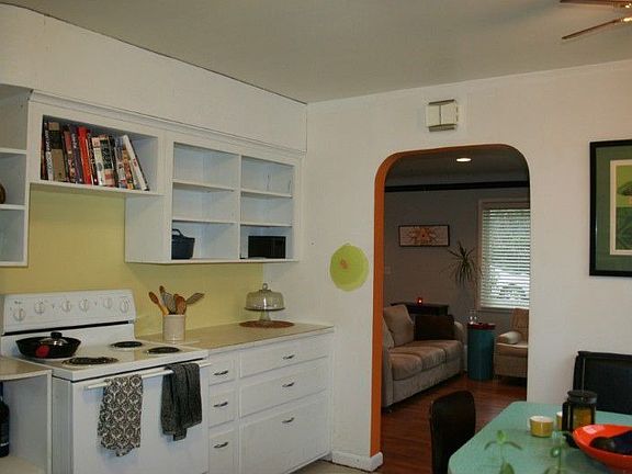 Arched entryways lead from kitchen to living room and living room to bedrooms.
