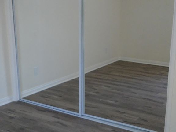 Master bedroom with glass mirrored closet doors.