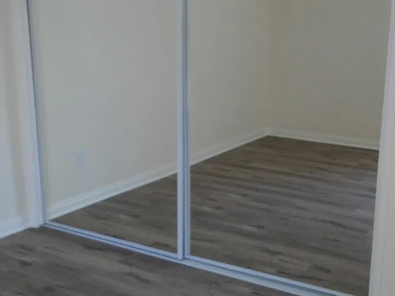 Master bedroom with glass mirrored closet doors.