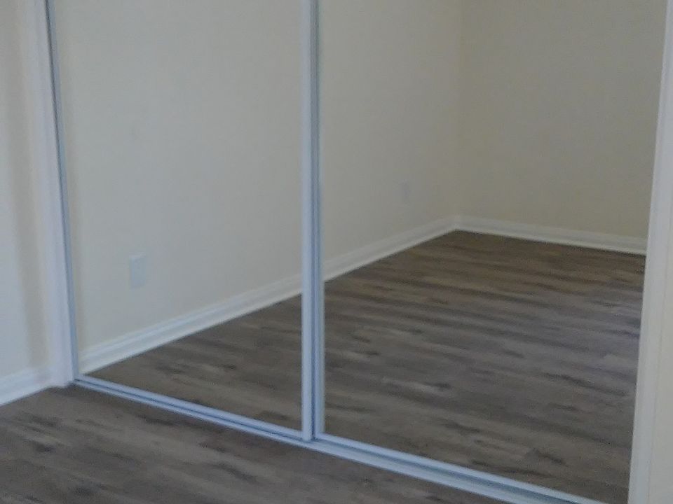 Master bedroom with glass mirrored closet doors.