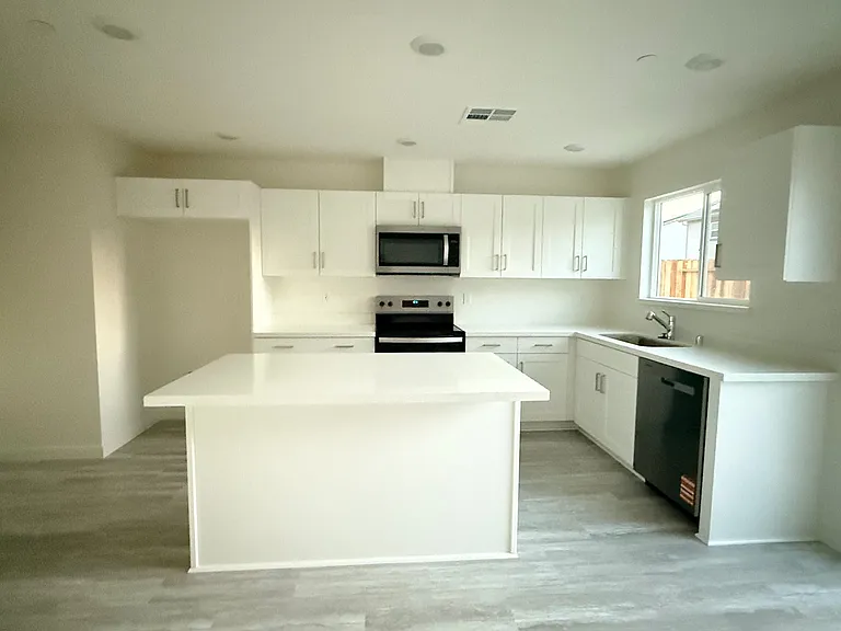 Clean, modern kitchen with quartz countertops, brand new stainless steel appliances, and soft close cabinets