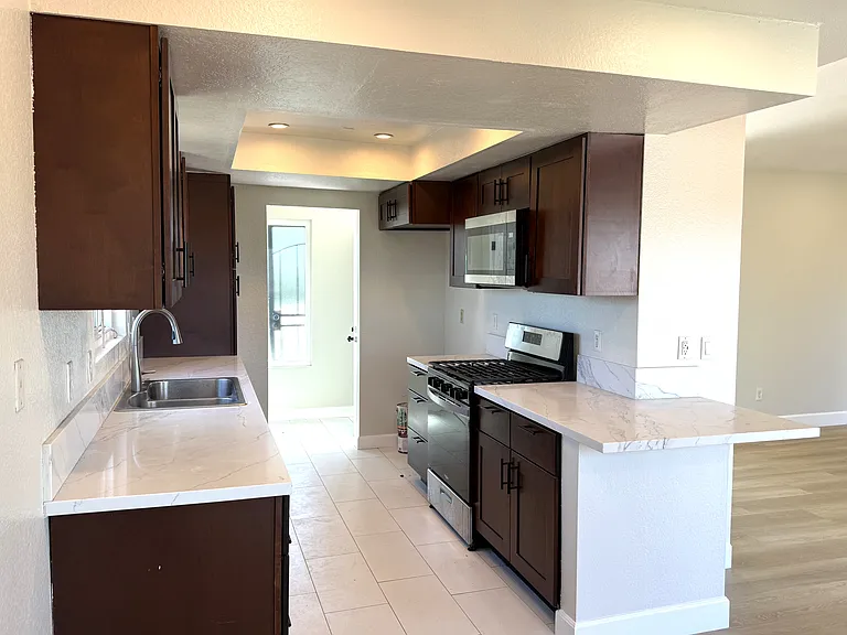 Kitchen viewed from dining room with living room to the right