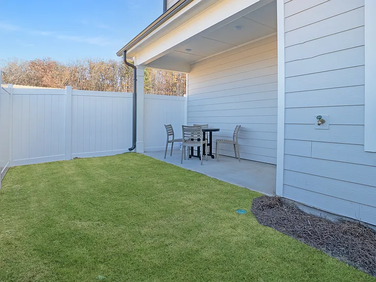 Covered back patio with fenced-in backyard