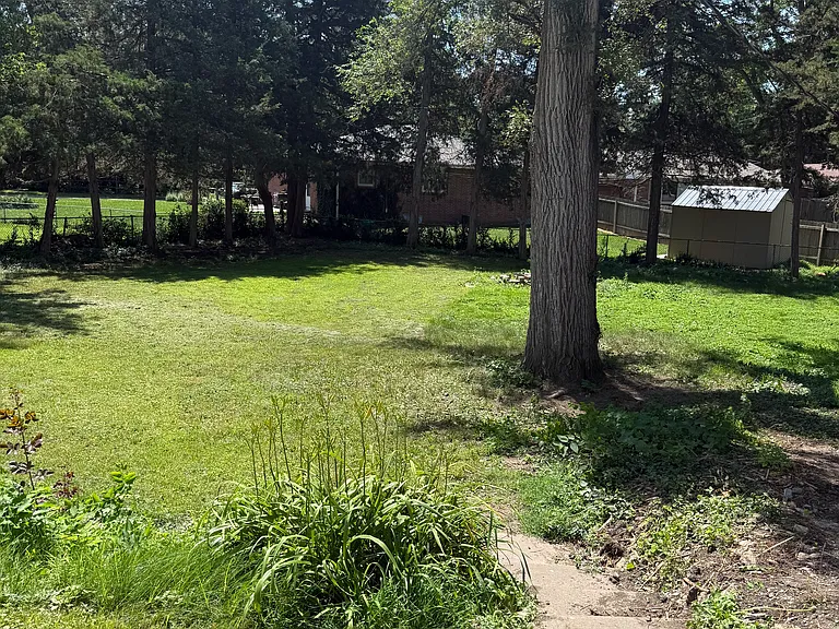 This is a park like completely enclosed back yard_very large space. Tree lined with single garage at end of extra long drive. Added width parking at east side of current driveway