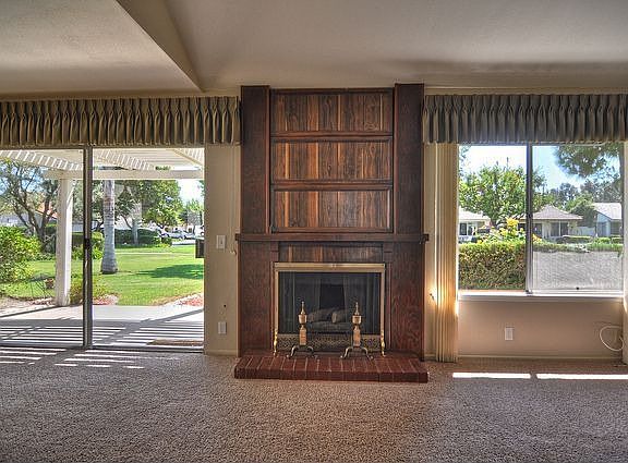 Cozy fireplace surrounded by windows and view of greenbelt.