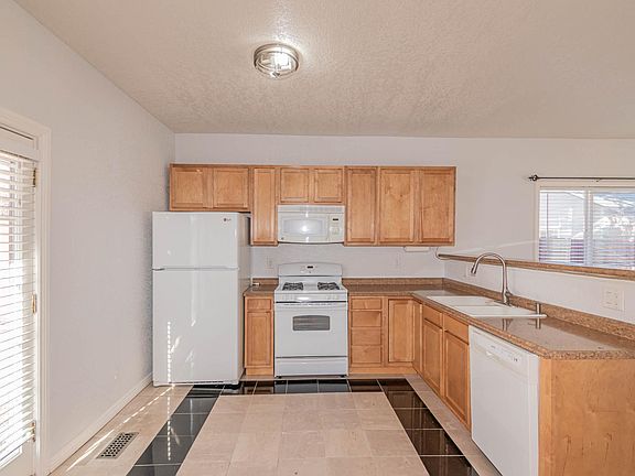 Spacious Kitchen with easy to clean marble flooring. Appliances include dishwasher, refrigerator/freezer, microwave, and gas range/oven.