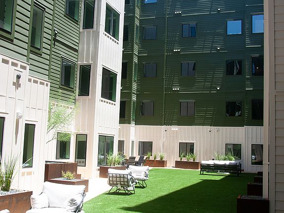 Solarium with turf and beautiful landscaping surrounding ample community seating.