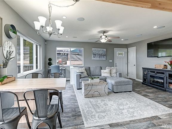 Home as seen from the kitchen area. The electric fireplace console is negotiable. There is a gas hookup behind it as well. TV stays. 