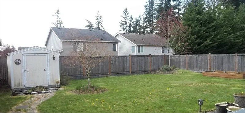 Fully fenced level backyard with garden space and a shed for extra storage!