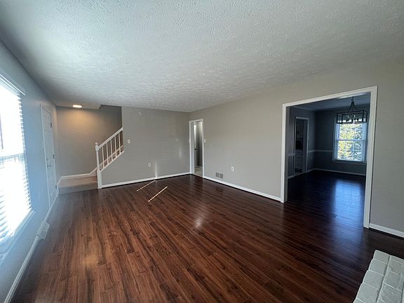 Living room - with staircase going upstairs. Front door is on left, before stairs. Dining room is on the right.
